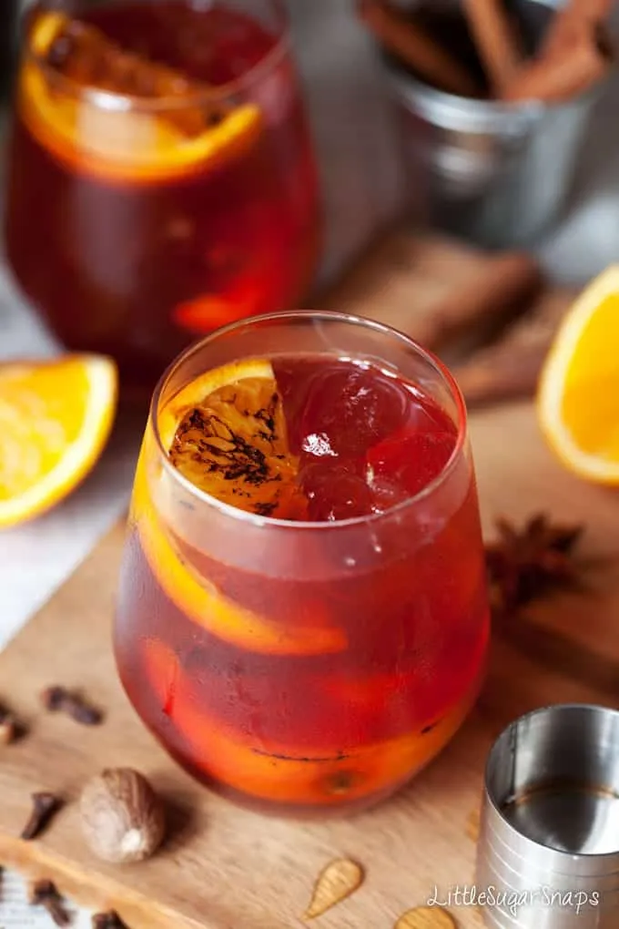Ein frisch zubereiteter Winter-Gewürz-Negroni mit karamellisierter Orangengarnitur