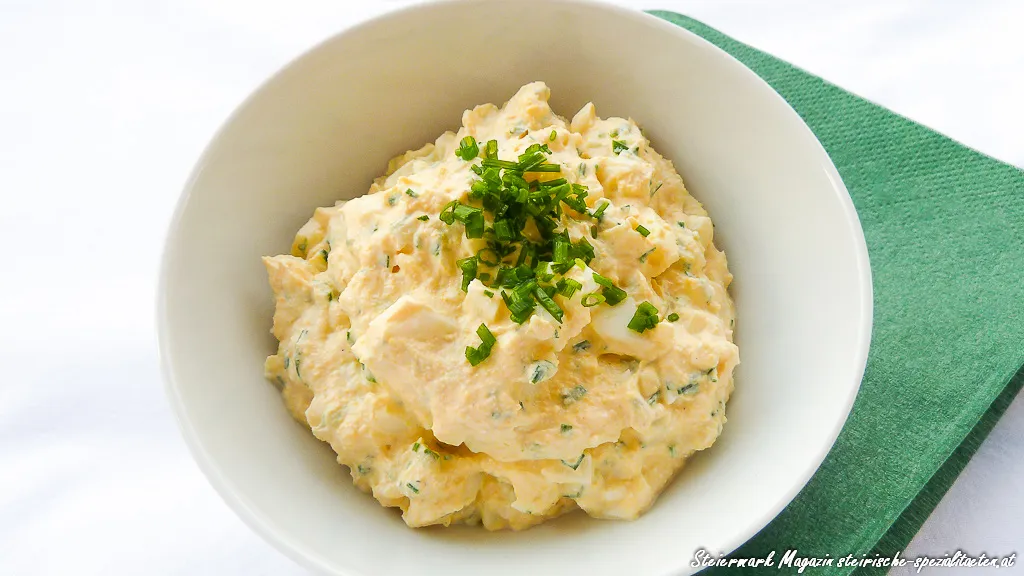 Ein frischer, cremiger Eiaufstrich mit viel Schnittlauch in einer kleinen Schale, bereit zum Servieren