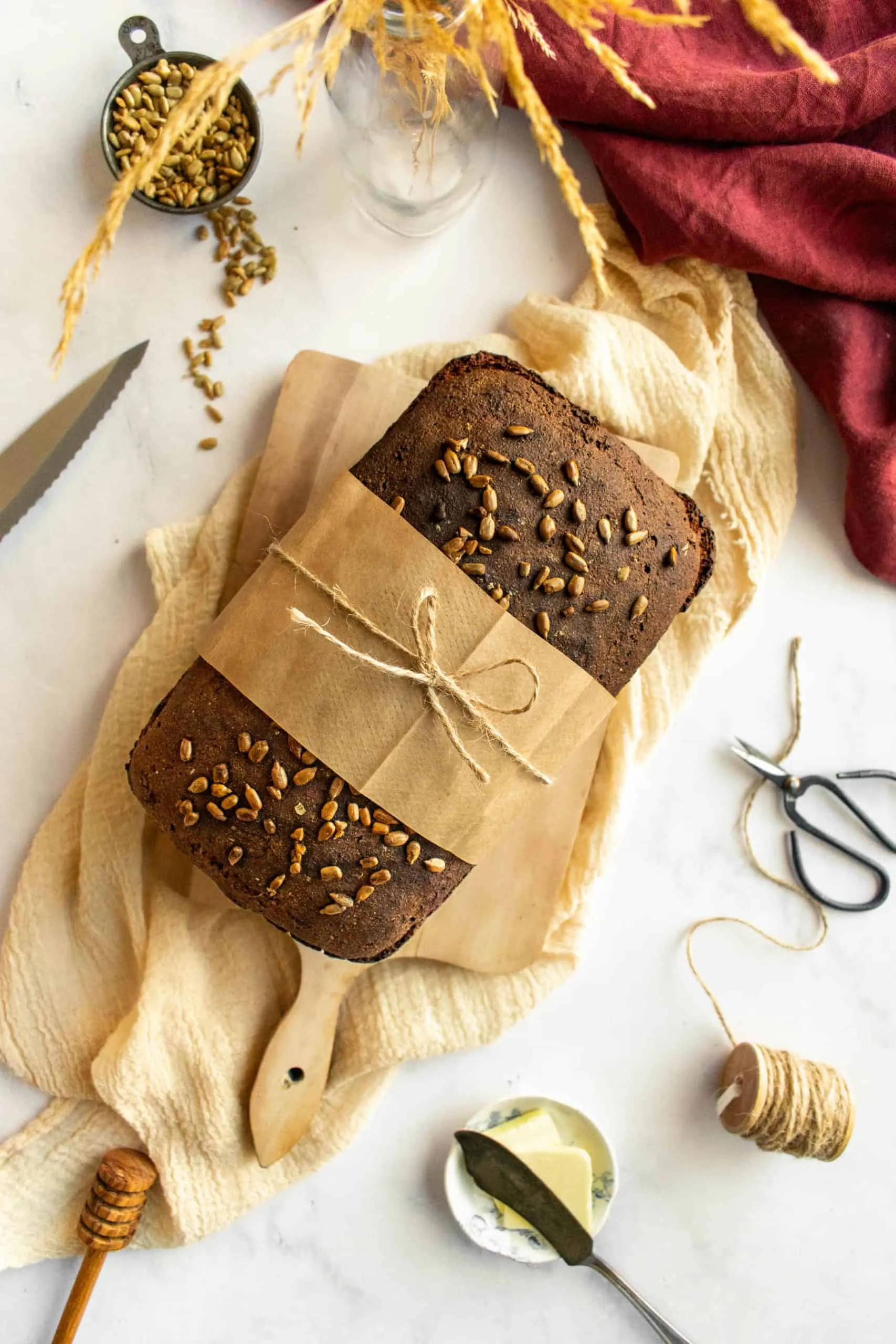 Ein ganzer Laib deutsches Schwarzbrot, mit Packpapier und Schnur gebunden.