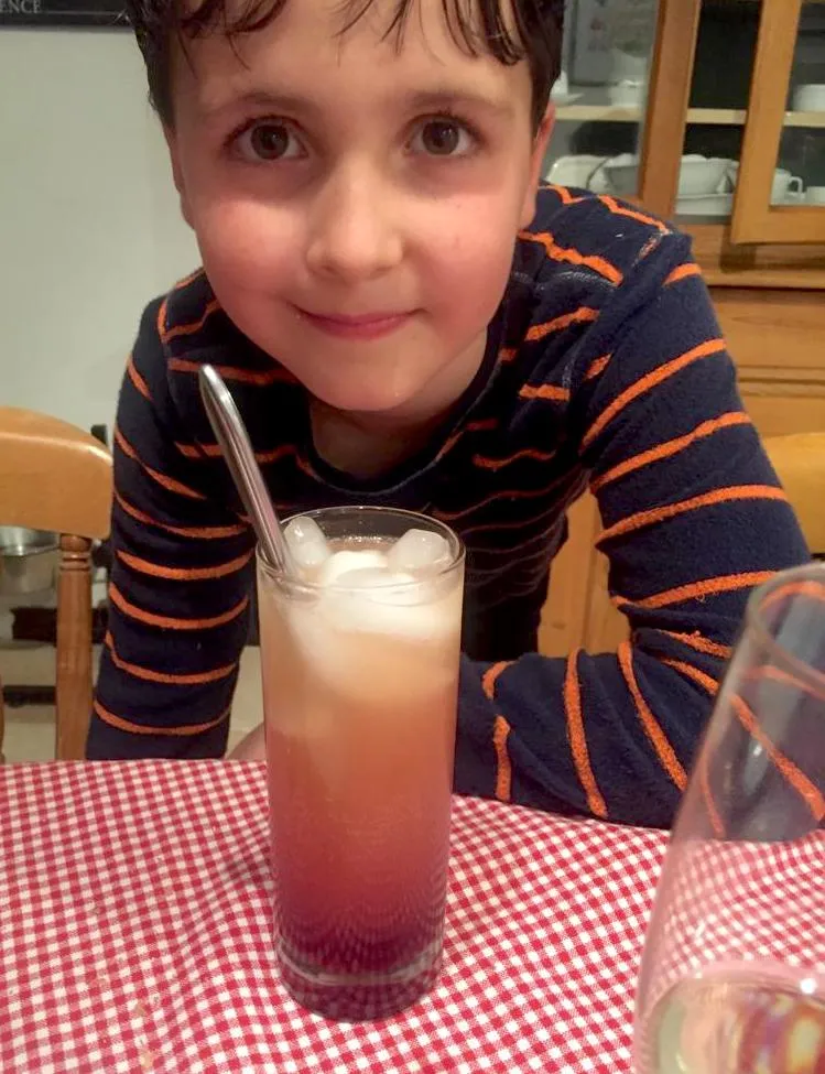 Ein Glas L'Indien, gefüllt mit Eiswürfeln und einer Orangenscheibe