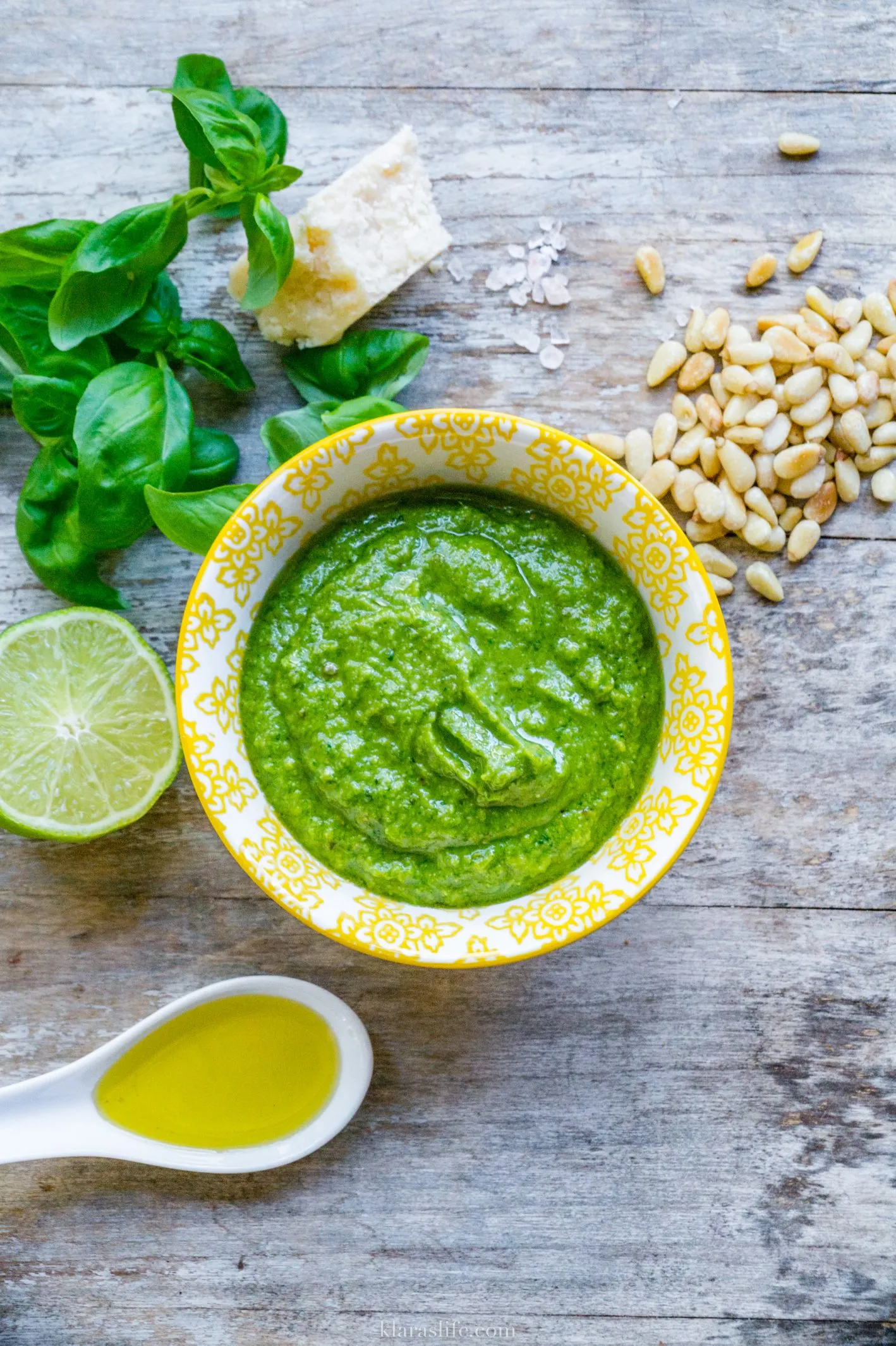 Ein Glas mit frischem, hausgemachtem Basilikumpesto auf einem Holztisch, bereit zum Servieren