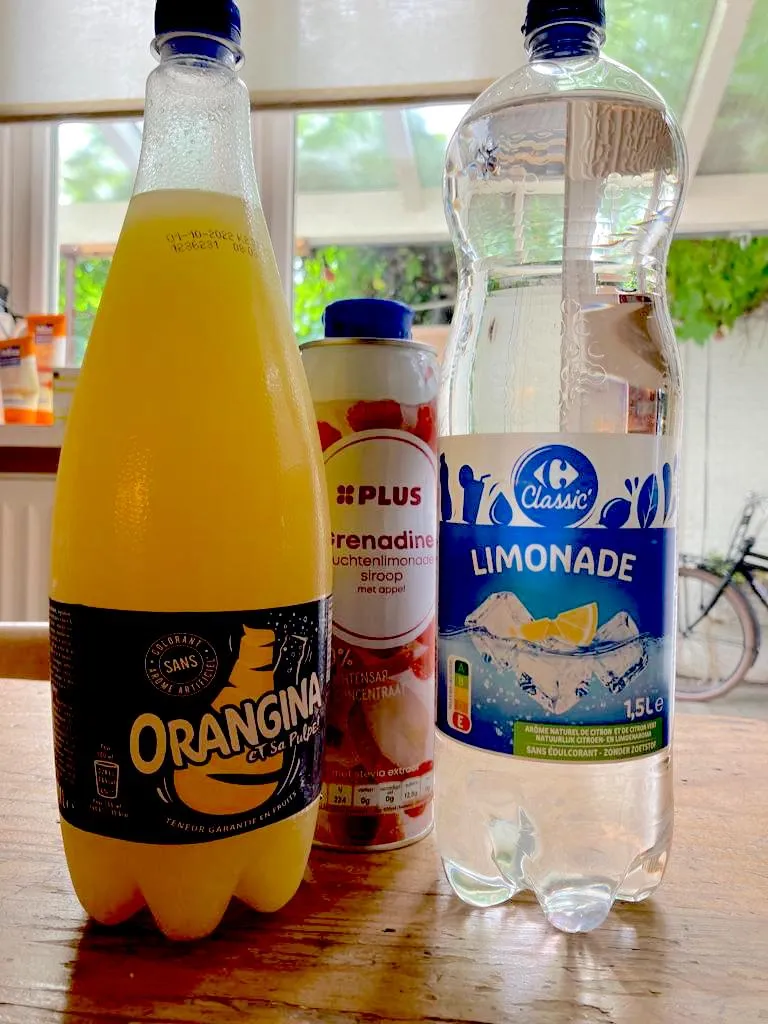 Ein Glas Orangina Grenadine Limonade, garniert mit einer Orangenscheibe
