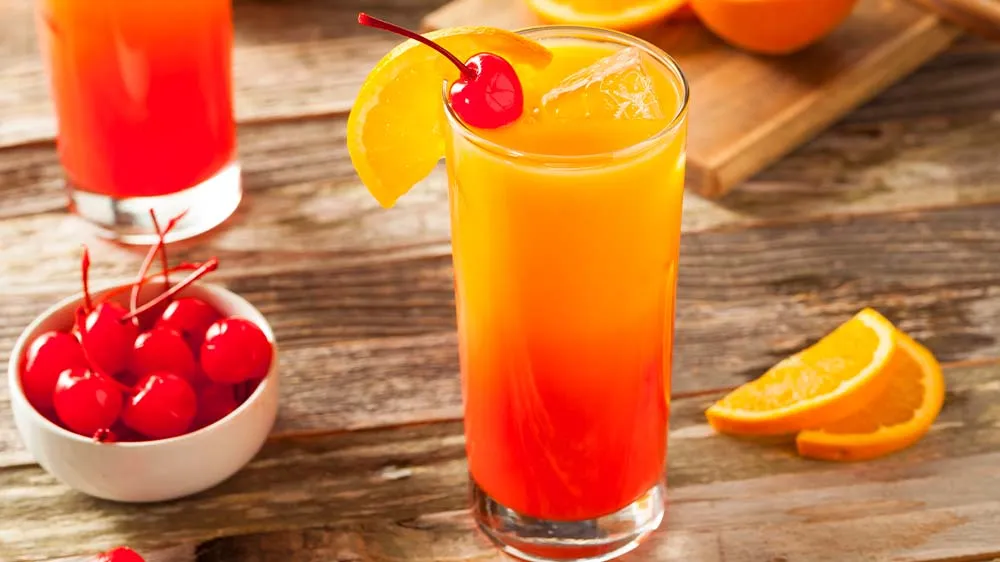 Ein Glas Virgin Sunrise, das den wunderschönen Farbverlauf von Gelb zu Rot zeigt