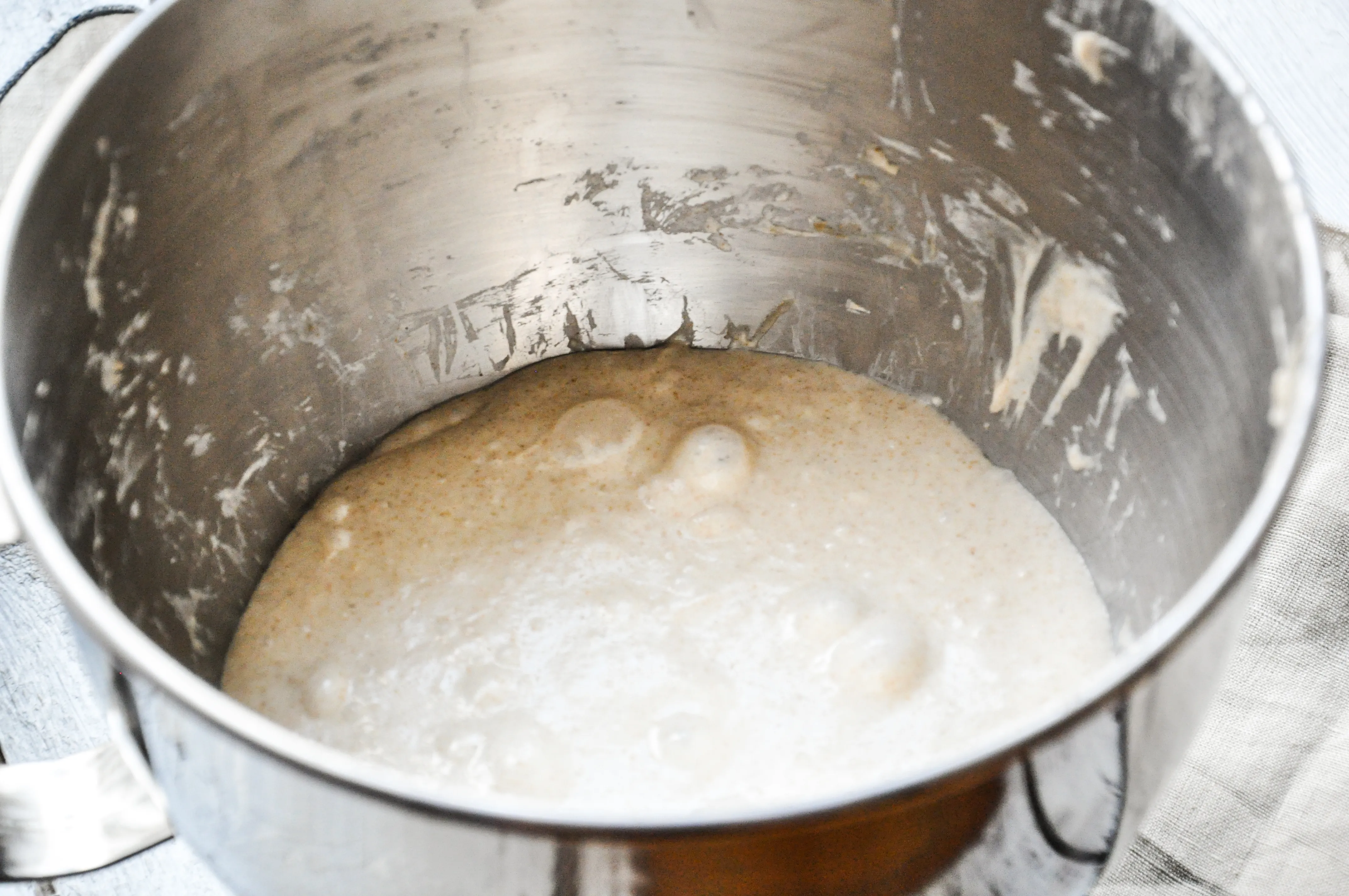 Ein glatter, elastischer Brotteig, der gerade gedehnt und gefaltet wird.