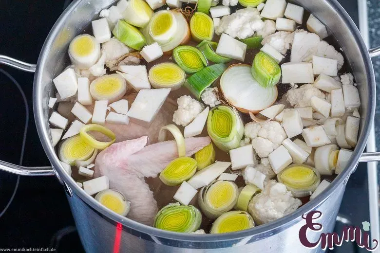 Ein großer Suppentopf auf dem Herd, unverzichtbar für die Zubereitung einer klassischen Hühnersuppe.