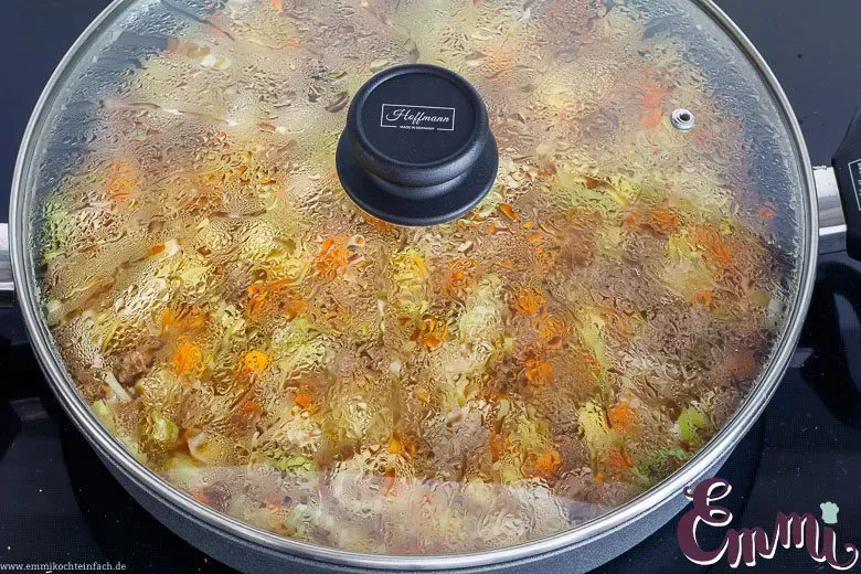 Ein großer Topf mit dem Bauerntopf, bedeckt mit einem Deckel, während er köchelt