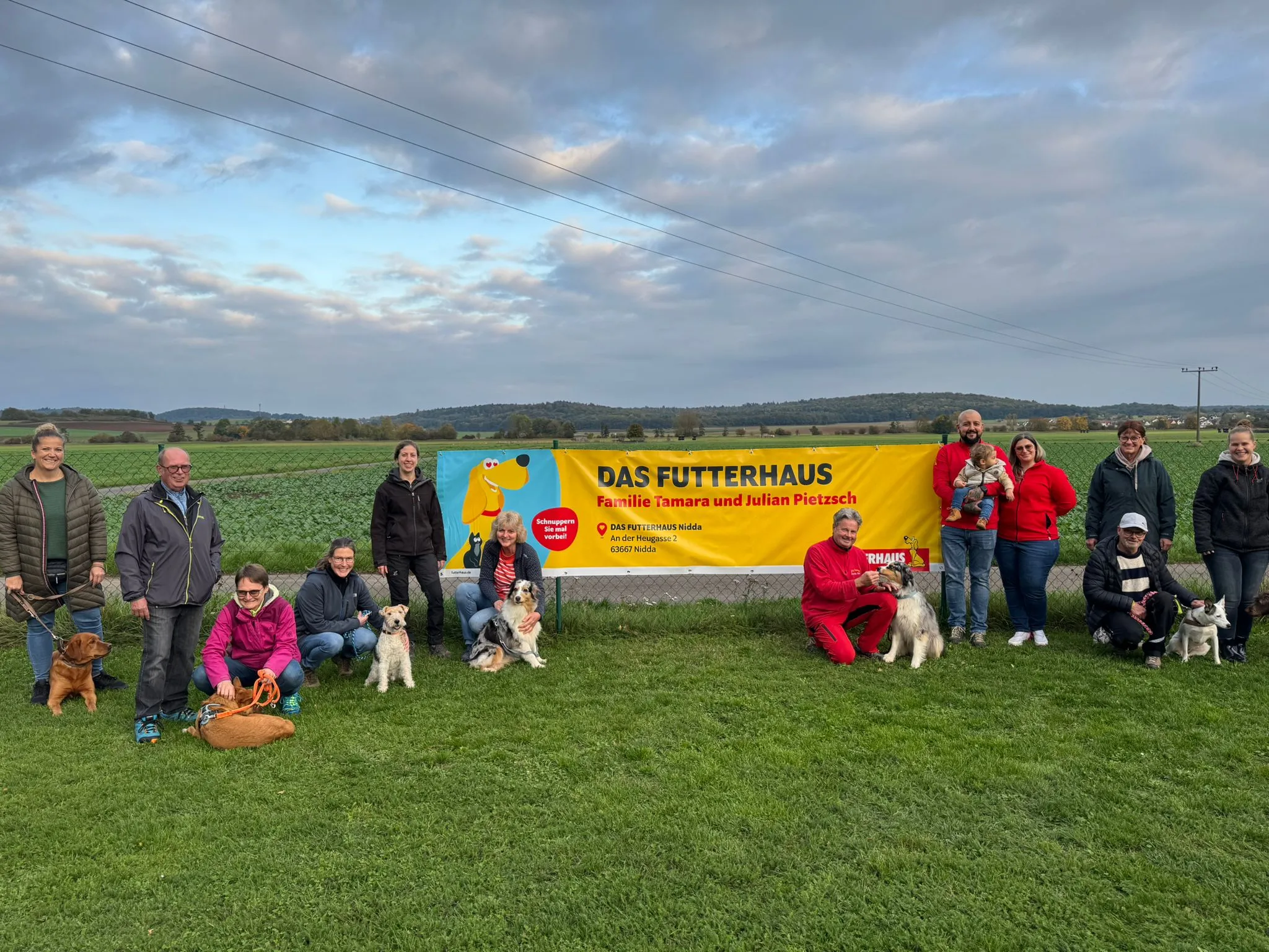 Ein großes Banner mit der Aufschrift "Futterhaus Nidda Partner des Hundevereins TAO" hängt an einer Gebäudewand.
