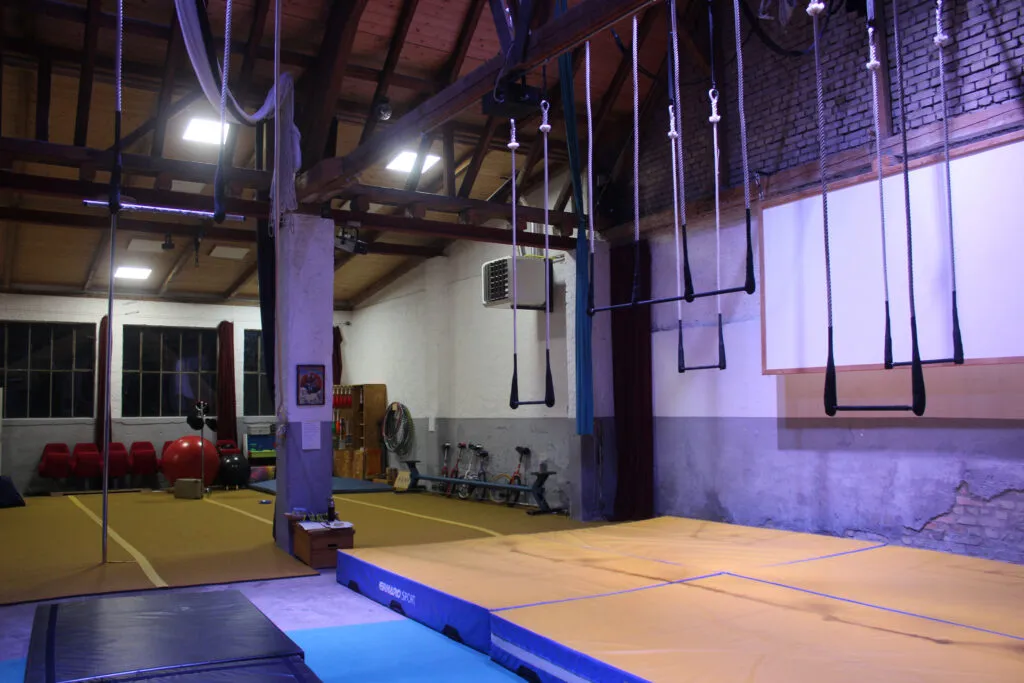 Ein heller, geräumiger Innenraum der Zirkusscheune Hochstetten mit verschiedenen Zirkusgeräten