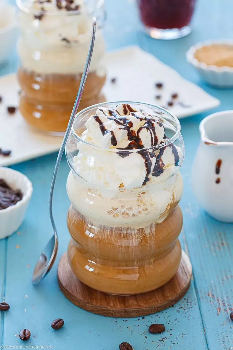 Ein hohes Glas Eiskaffee mit Vanilleeis, Sahnehaube und Schokostückchen