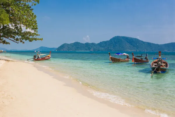 Ein idyllischer Strand in Rawai, Phuket, Thailand, mit Palmen und azurblauem Wasser.