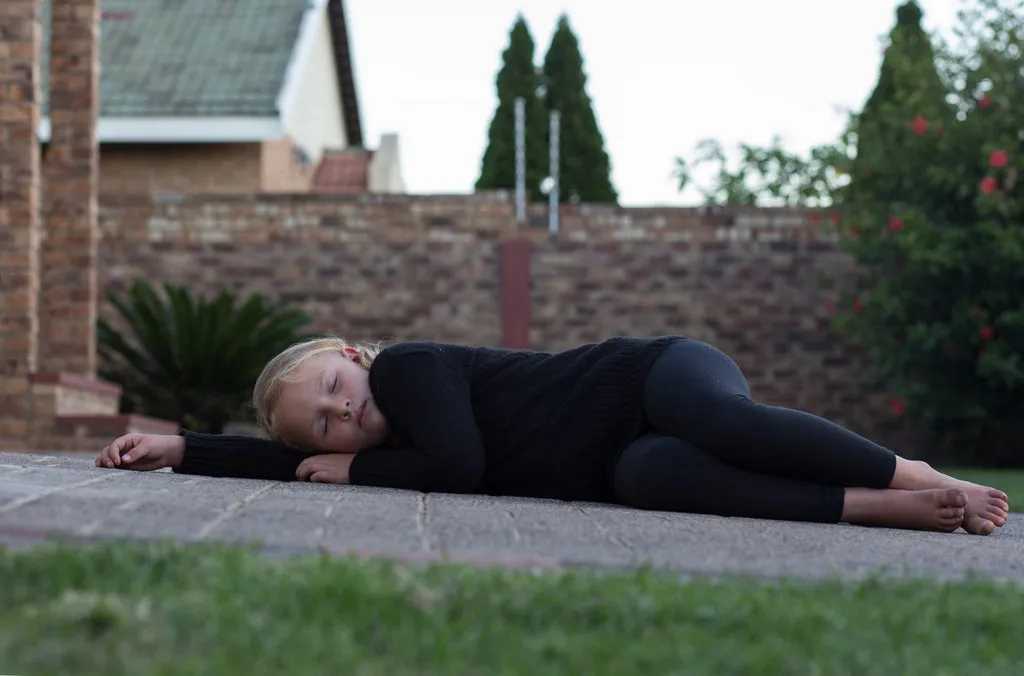 Ein Kind, das in einer schlafenden Position posiert