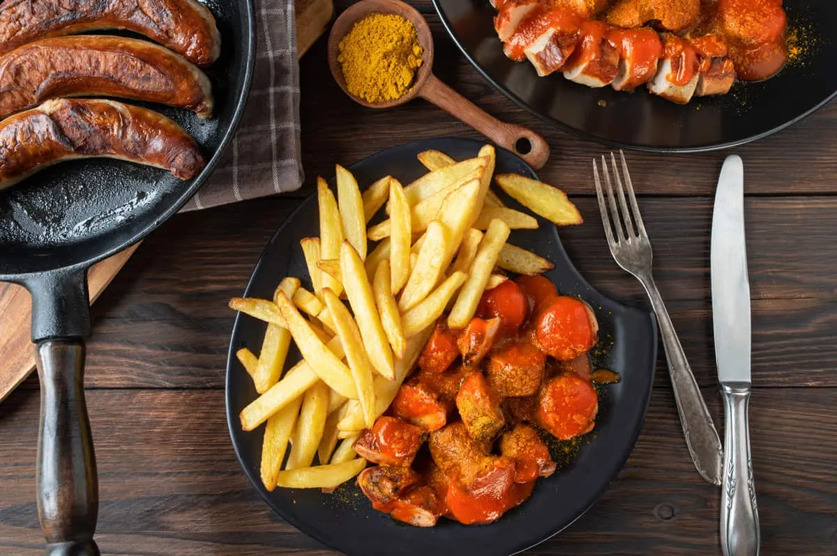Ein klassischer Berliner Imbissstand mit Currywurst-Angebot, typisch für die deutsche Straßenküche