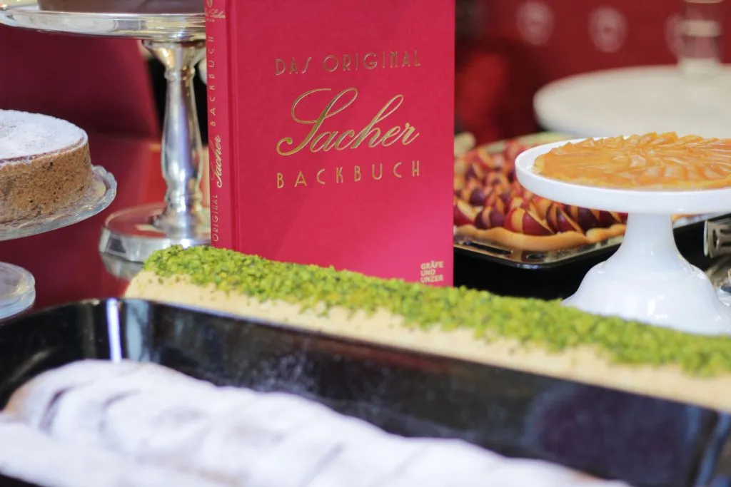 Ein Koch bereitet frischen Kaiserschmarrn in einer großen Pfanne zu, begleitet von Apfelmus