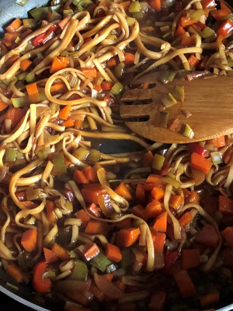 Ein köstlich angerichtetes Wok-Gericht mit viel Gemüse und Udon Nudeln