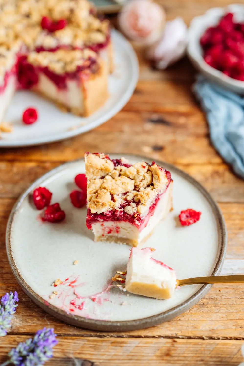 Ein köstlich aussehendes Stück Himbeer-Streusel-Joghurt-Käsekuchen auf einem Teller