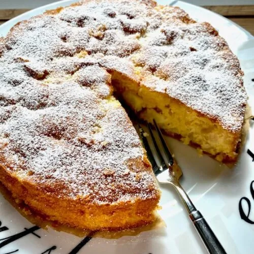 Ein köstlicher Apfelkuchen mit Rührteig, leicht mit Puderzucker bestäubt, bereit zum Genießen