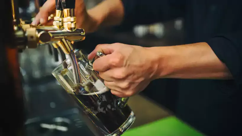 Ein kühles Schwarzbier in einem hohen Glas mit Schaumkrone, bereit zum Genuss
