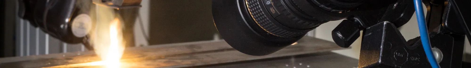 Ein Laborbanner mit der Aufschrift „Lehrstuhl für Photonische Technologien“ und einem Bild komplexer optischer Komponenten