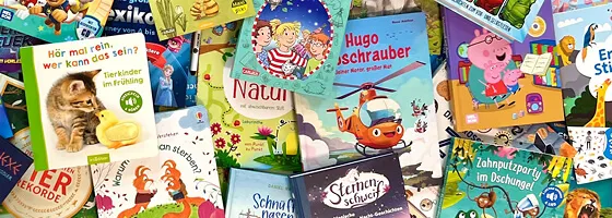 Ein lachendes Kind hält stolz ein neu erworbenes Kinderbuch in den Händen.