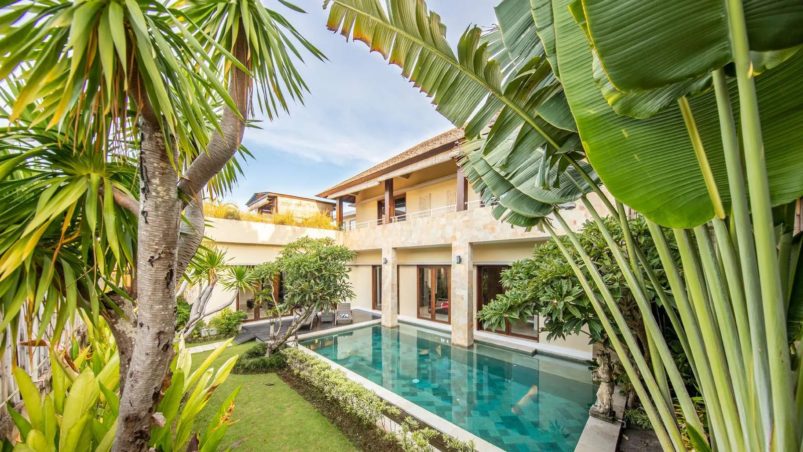Ein luxuriöser Pool in Canggu auf der indonesischen Insel Bali, umgeben von tropischer Vegetation.