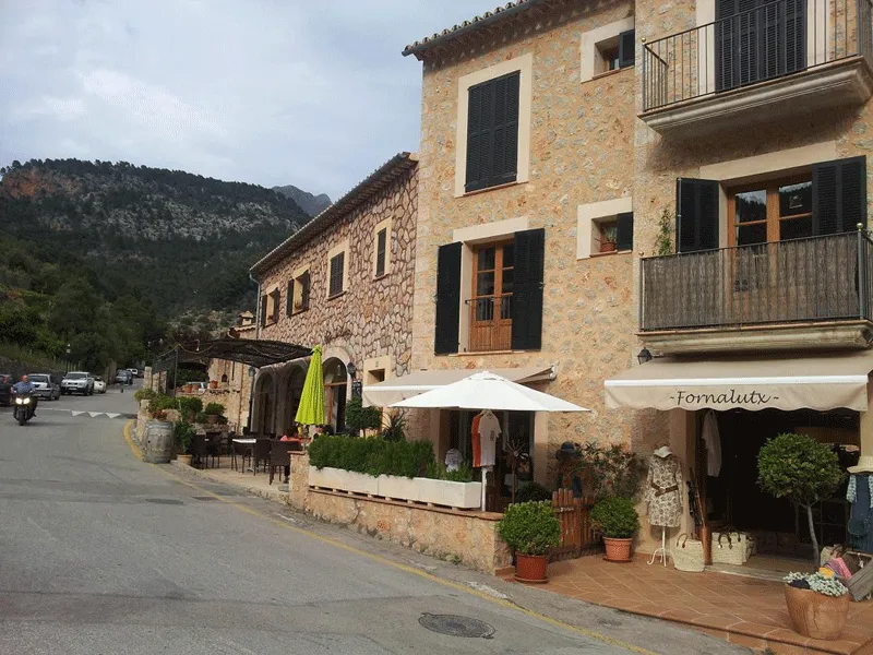 Ein malerisches Bergdorf an der Westküste Mallorcas, umgeben von grünen Hügeln