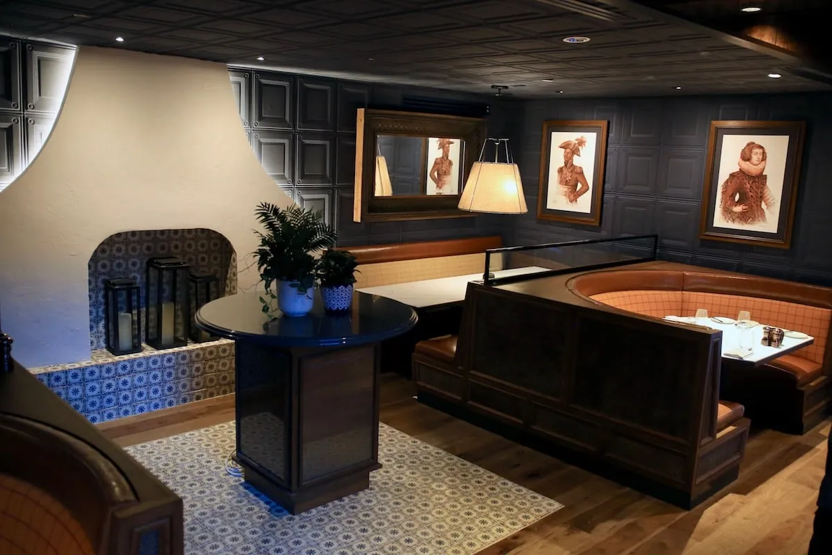 Ein marokkanischer Tajine-förmiger Kamin ist mit zahlreichen Kerzen gefüllt und schafft eine warme, einladende Atmosphäre im Lounge-Bereich.