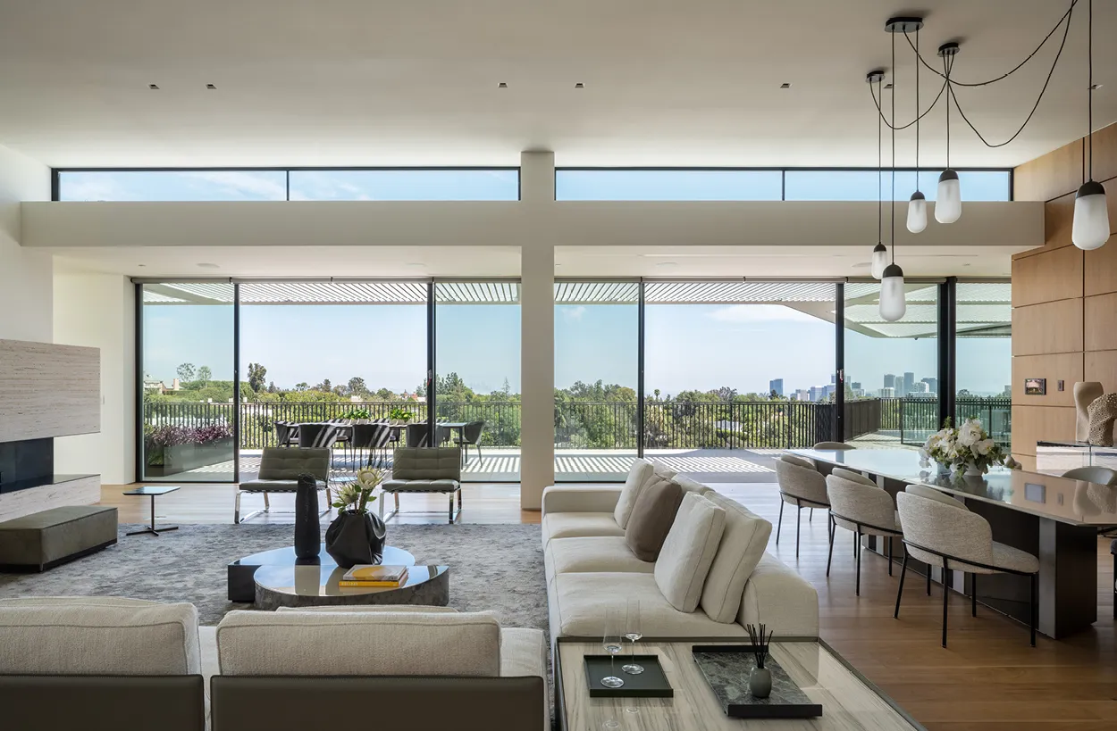 Ein modernes Foyer mit hohen Decken, großen Fenstern und einem eleganten Treppenhaus, das den Raum anker.