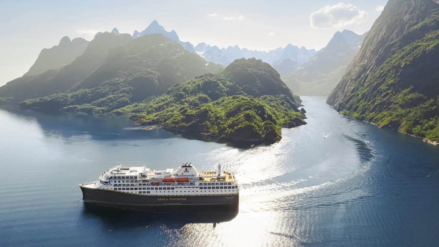 Ein modernes Havila Voyages Schiff gleitet durch einen norwegischen Fjord