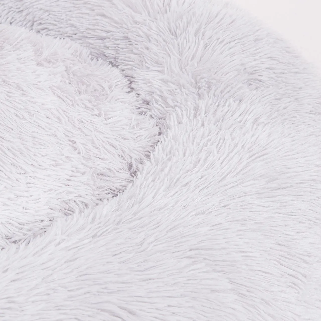 Ein Nahaufnahme des flauschigen Materials des hellgrauen Katzenbettes