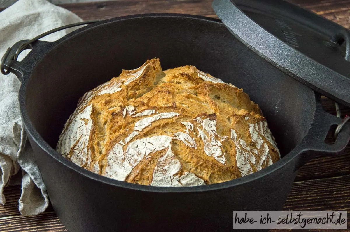 Ein rundes Bauernbrot, das in einem gusseisernen Dutch Oven im Ofen gebacken wird