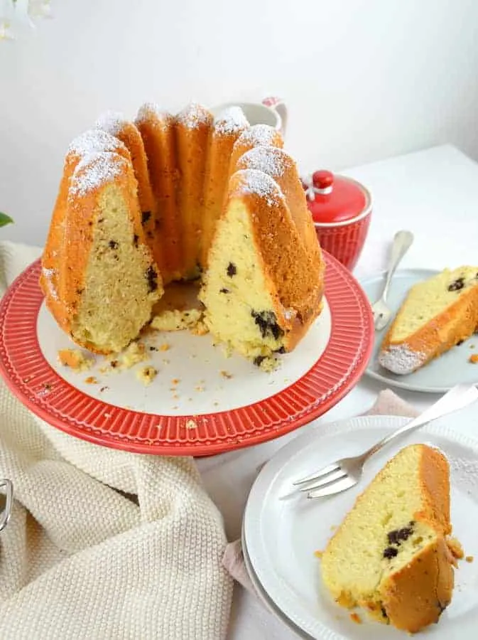 Ein saftiger Gugelhupf nach Omas Rezept mit Puderzucker bestäubt auf einem Rost