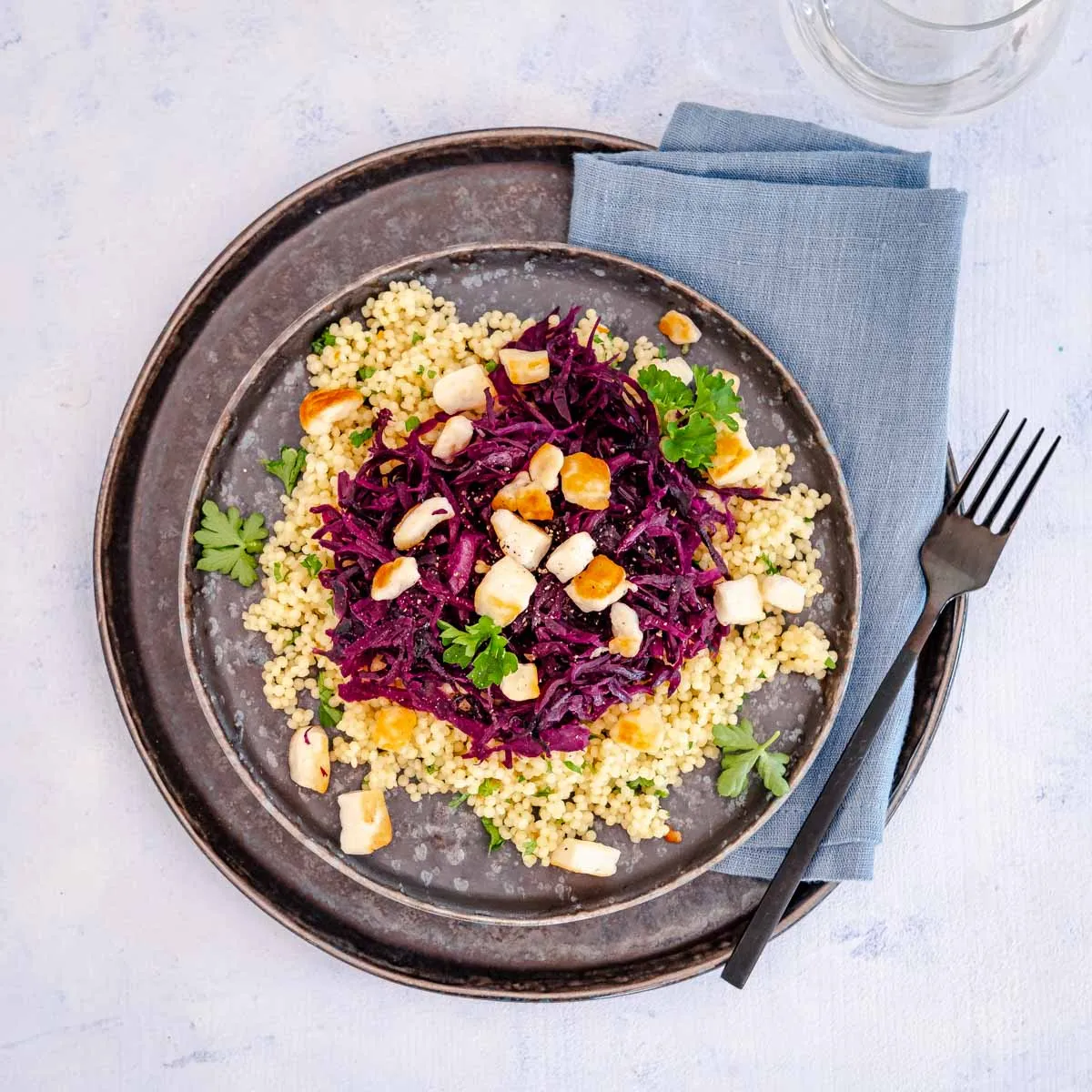 Ein stilisiertes Bild eines vorbereiteten Tellers mit Rotkraut-Couscous und gebratenem Halloumi, bereit zum Servieren