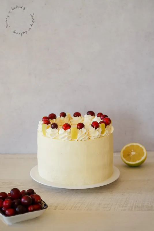 Ein Stück der Cranberry-Zitronen-Torte auf einem Teller serviert, mit frischen Beeren dekoriert