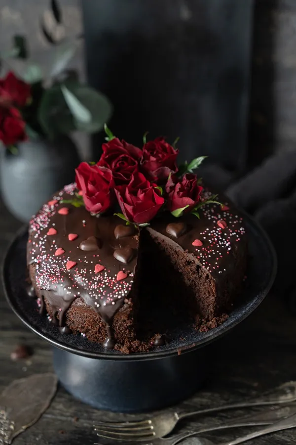 Ein Stück des kleinen Schokoladenkuchens mit einem Herz aus Zuckerdekor, perfekt für eine romantische Geste