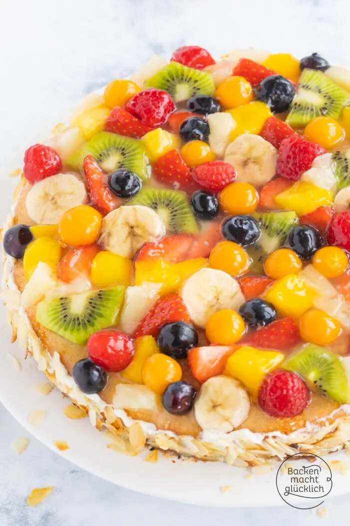 Ein Stück einer bunten Obsttorte mit cremigem Belag