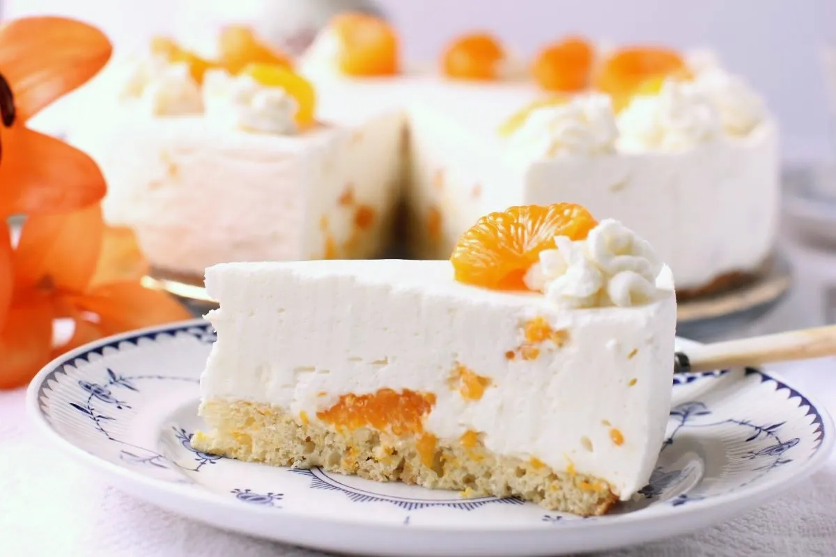 Ein Stück Mandarinen-Sahnetorte auf einem blau-weißen Teller