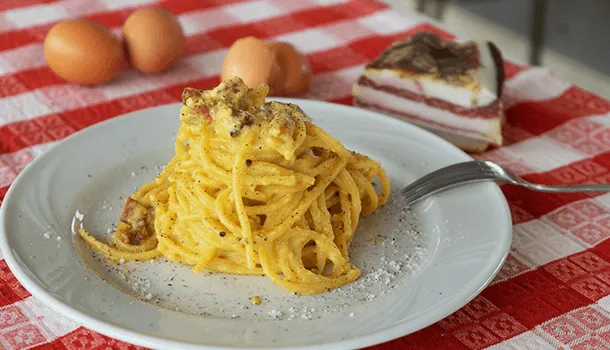 Ein Teller mit perfekt zubereiteten Spaghetti Carbonara, garniert mit frischem Pfeffer