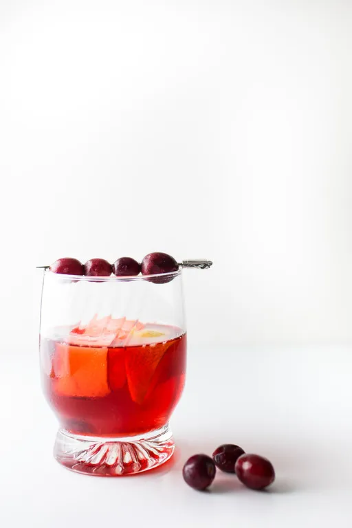 Ein tiefroter Cocktail mit Cranberries als Garnitur, ideal für festliche Anlässe