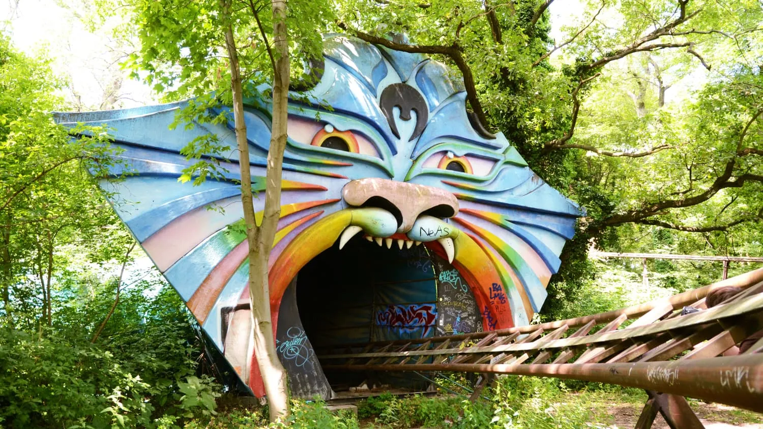 Ein Tigermaul, in das Achterbahnschienen führen in einem Park