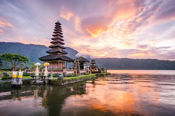 Ein traditioneller Tempel auf Bali bei Sonnenuntergang, umgeben von Wasser