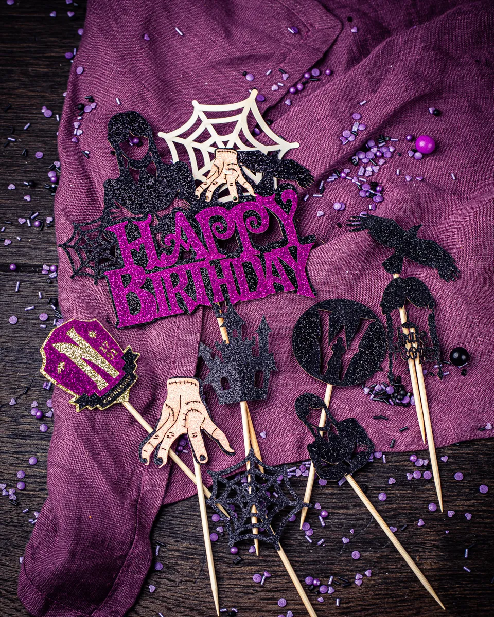 Ein Wednesday Geburtstagskuchen mit verschiedenen Tortensteckern und Dekorationen