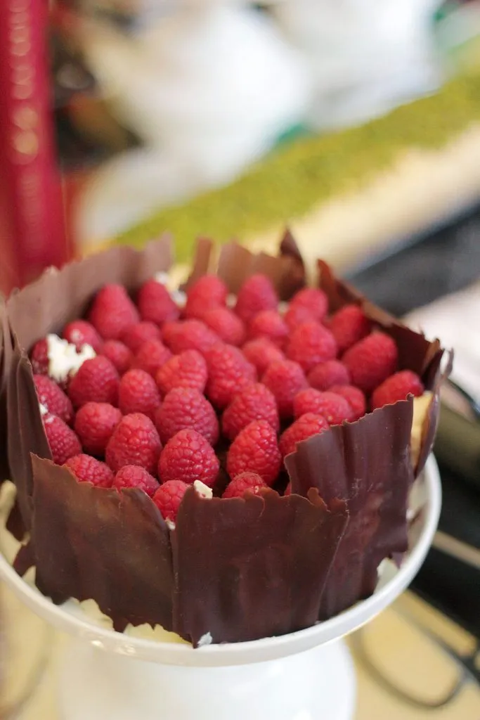 Ein wunderschön gestaltetes Sacher Backbuch, umgeben von köstlichen Sacher Torte Stücken und Pralinen