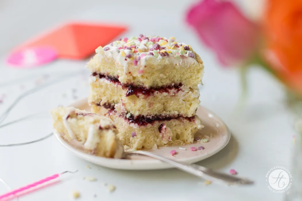 Ein wunderschönes kleines Geburtstagstörtchen mit Joghurtcreme, Konfitüre und bunten Zuckerstreuseln, bereit zum Servieren.