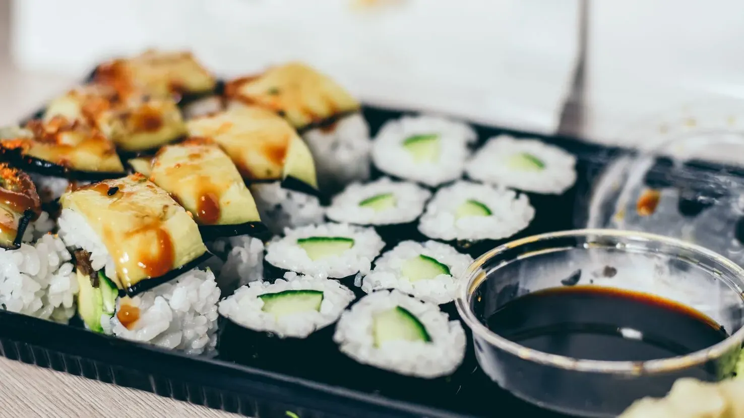 Eine appetitliche Sushi-Box gefüllt mit verschiedenen Maki- und Nigiri-Variationen, bereit zum Mitnehmen.