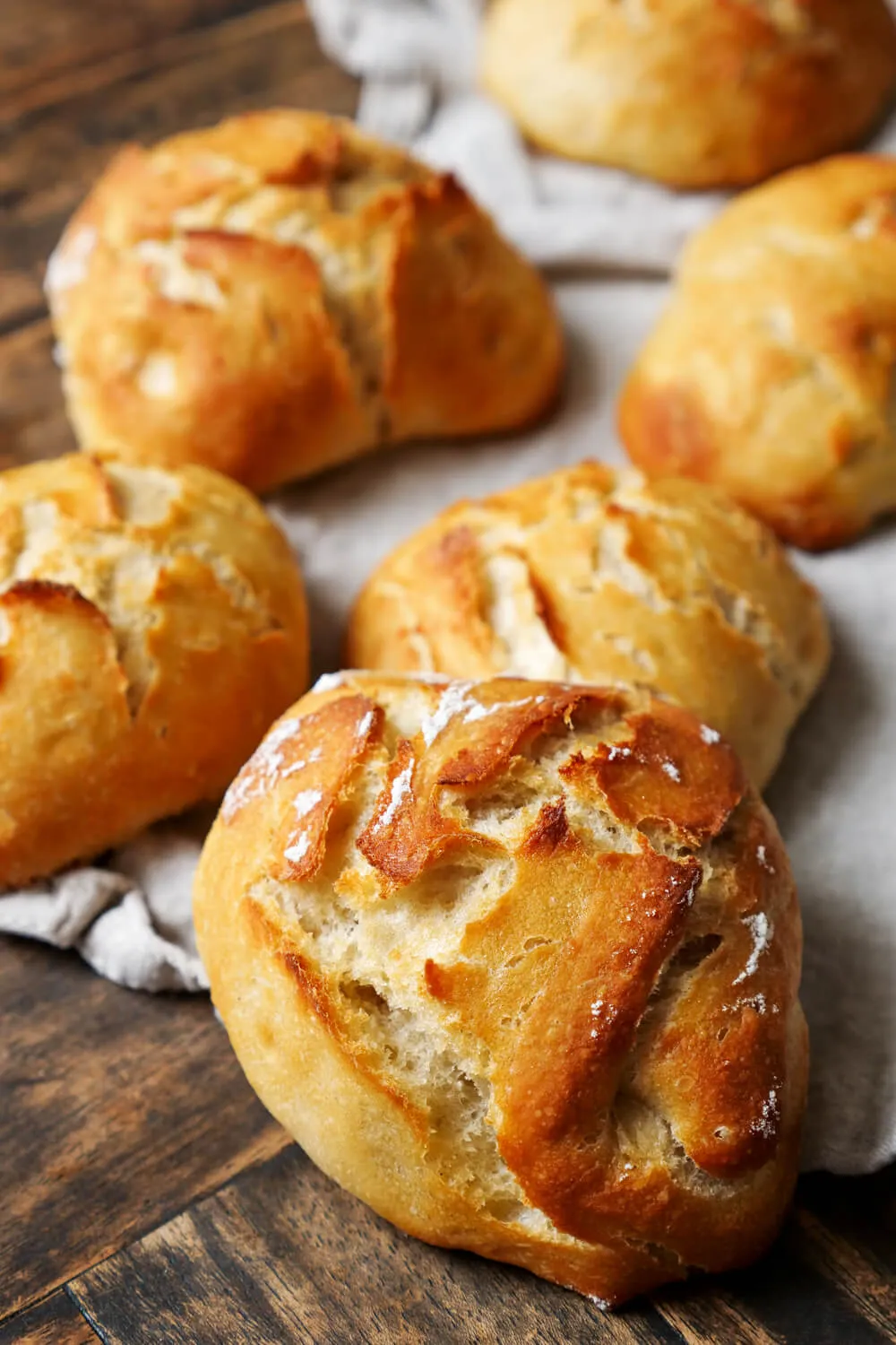 Eine Auswahl frisch gebackener Brötchen mit Hefe, einige bestreut mit Sesam oder Mohn