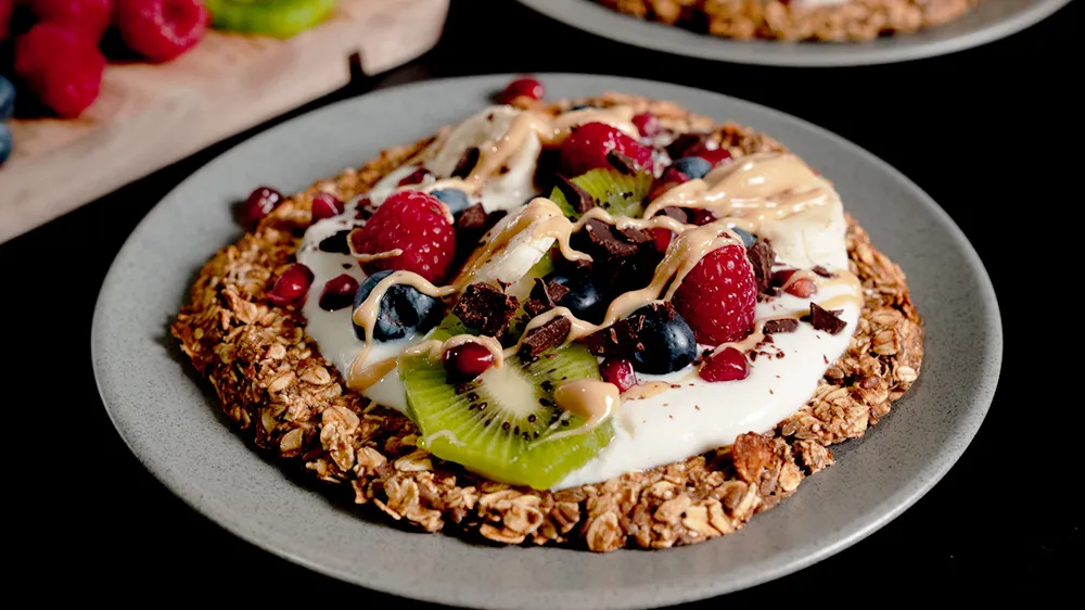 Eine bunte Frühstückspizza mit viel Obst und Joghurt, appetitlich angerichtet.