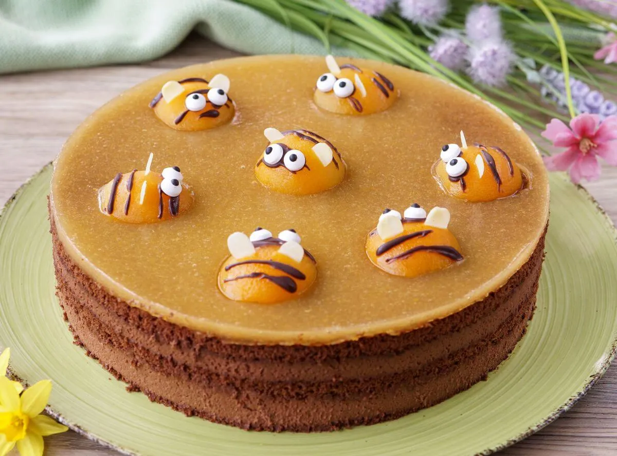 Eine elegante Schoko-Sahne-Torte verziert mit Aprikosenbienen, perfekt für jede Feier