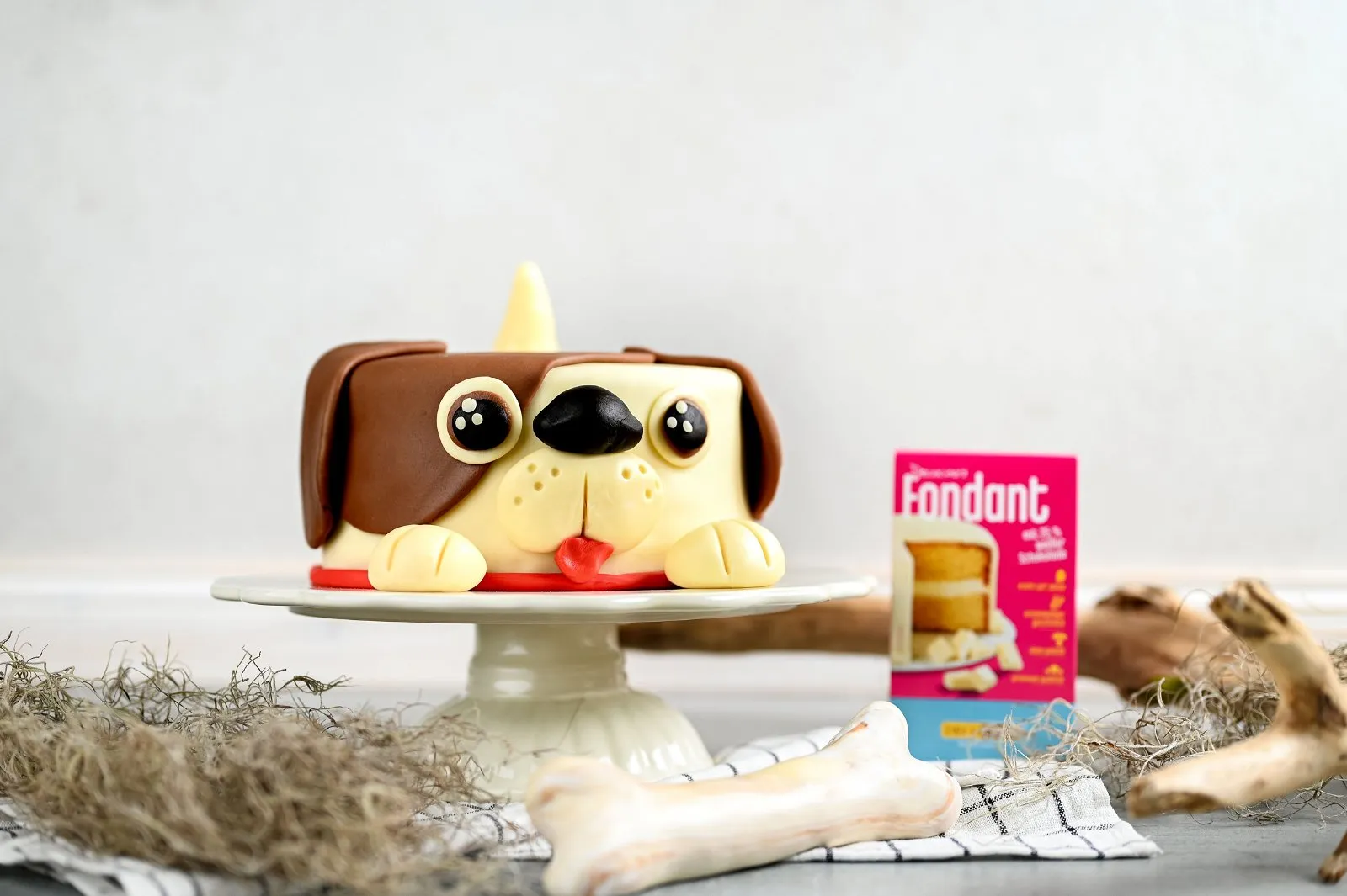 Eine festliche Torte mit detailreichem Hundemotiv, bedeckt mit farbigem Fondant und Schokoladenbiskuit