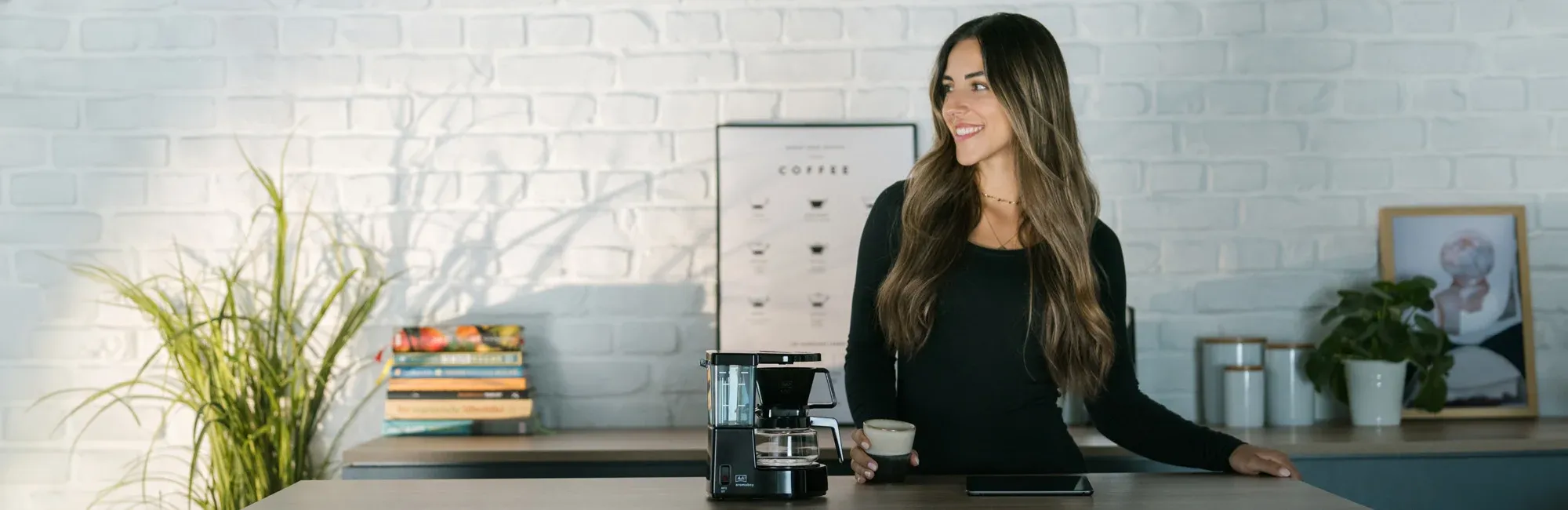 Eine Frau genießt frisch gebrühten Filterkaffee aus der Aromaboy Kaffeemaschine