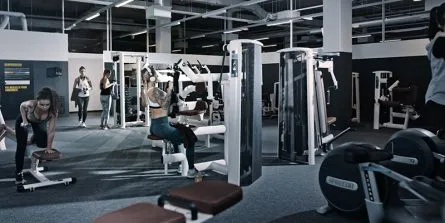 Eine Frau trainiert an einem modernen Cardio-Gerät in einem Damen-Fitnessbereich